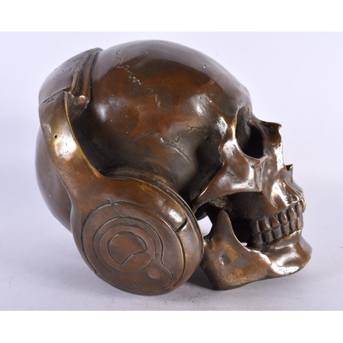 427 - A LARGE CONTEMPORARY BRONZE SKULL AND HEADPHONES MODEL. 18cm x 16 cm.