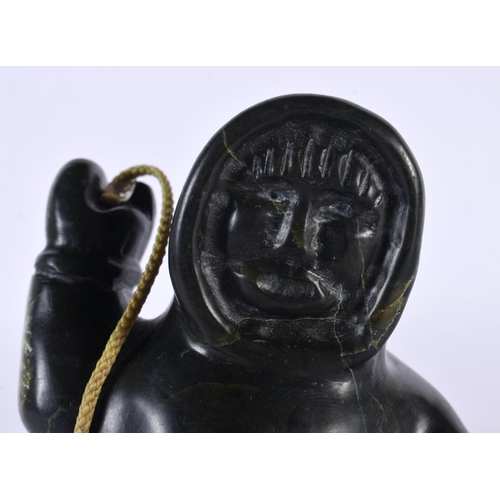 451 - A NORTH AMERICAN CARVED JADE INUIT FIGURE OF AN ESKIMO SEAL HUNTER modelled holding a spear and rope... 