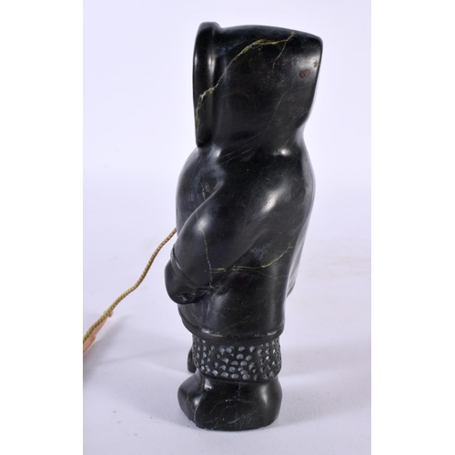 451 - A NORTH AMERICAN CARVED JADE INUIT FIGURE OF AN ESKIMO SEAL HUNTER modelled holding a spear and rope... 