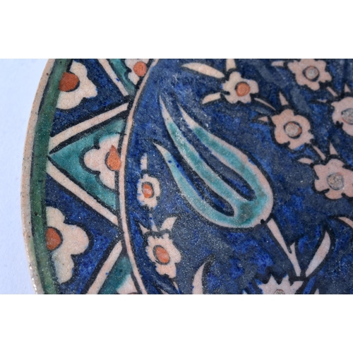 493 - A MIDDLE EASTERN FAIENCE IZNIK TYPE POTTERY BOWL. 18cm diameter.