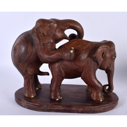 502 - A RARE ANGLO INDIAN CARVED HARDWOOD EROTIC FIGURE OF ELEPHANTS modelled as a rearing male ready to a... 