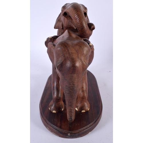 502 - A RARE ANGLO INDIAN CARVED HARDWOOD EROTIC FIGURE OF ELEPHANTS modelled as a rearing male ready to a... 