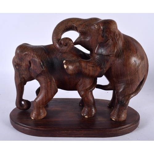 502 - A RARE ANGLO INDIAN CARVED HARDWOOD EROTIC FIGURE OF ELEPHANTS modelled as a rearing male ready to a... 