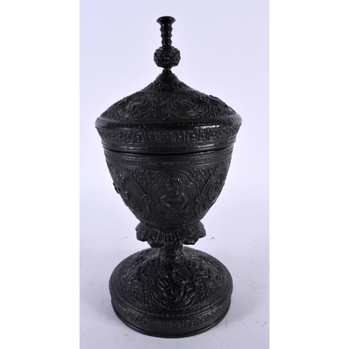 504 - AN ANTIQUE INDIAN HARDWOOD GOBLET AND COVER depicting figures in various pursuits. 25 cm high.