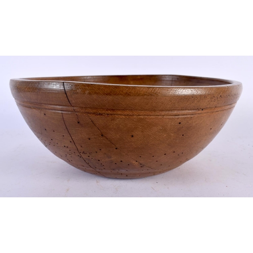 566 - A TREEN BUTTER BOWL with spoon. Largest 27 cm diameter. (2)