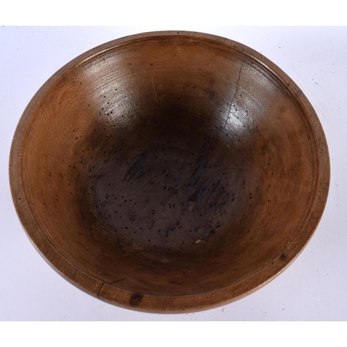 566 - A TREEN BUTTER BOWL with spoon. Largest 27 cm diameter. (2)