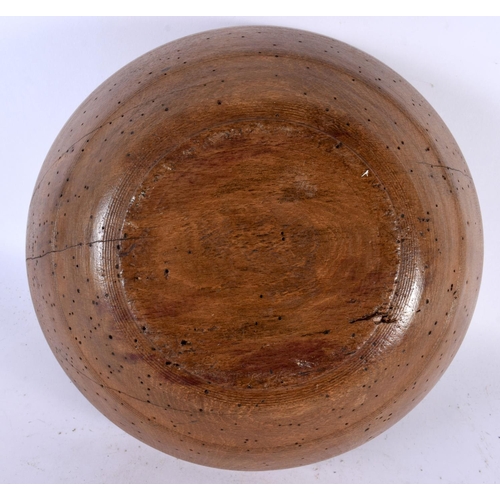 566 - A TREEN BUTTER BOWL with spoon. Largest 27 cm diameter. (2)