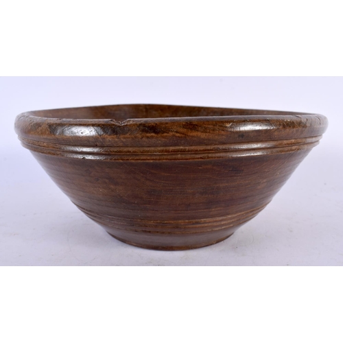 582 - A TREEN BUTTER BOWL with spoon. Largest 24 cm diameter. (2)