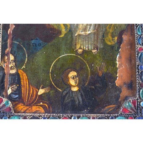 641 - AN 18TH/19TH CENTURY RUSSIAN PAINTED WOOD ICON within a champleve enamelled frame, decorated with fl... 