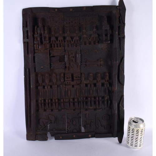 697 - AN AFRICAN TRIBAL CARVED WOOD DOGON DOOR depicting figures and animals. 52 cm x 38 cm.