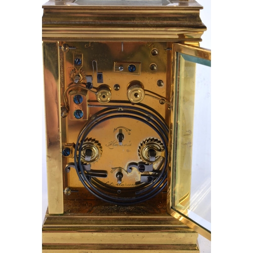 734 - AN ANTIQUE REPEATING BRASS CARRIAGE CLOCK. 18cm high inc handle.