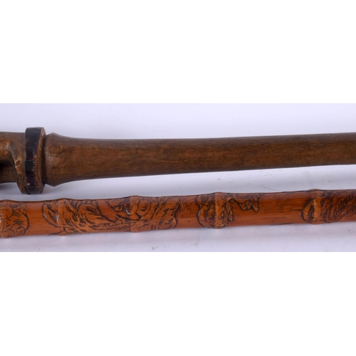 757 - AN EARLY 20TH CENTURY TRIBAL CARVED WOOD STAFF together with a Japanese bamboo walking cane. Largest... 