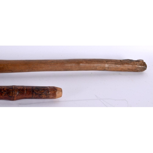 757 - AN EARLY 20TH CENTURY TRIBAL CARVED WOOD STAFF together with a Japanese bamboo walking cane. Largest... 