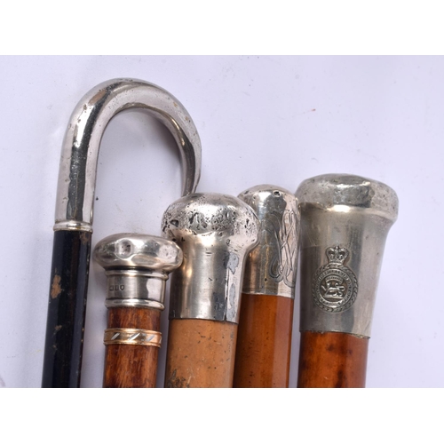 758 - FOUR ANTIQUE SILVER MOUNTED WALKING CANES together a Royal Leicestershire Regiment swagger stick. La... 