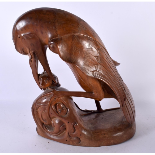 790 - A LARGE LATE 19TH CENTURY SOUTHEAST ASIAN CARVED WOOD FIGURE OF A BIRD modelled clutching a rat with... 