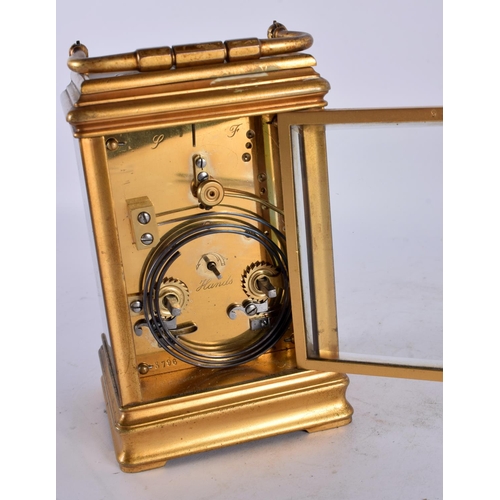 799 - AN ANTIQUE FRENCH REPEATING BRASS CARRIAGE CLOCK with enamel dial. 17 cm high inc handle.