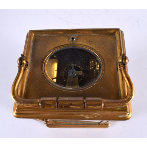 799 - AN ANTIQUE FRENCH REPEATING BRASS CARRIAGE CLOCK with enamel dial. 17 cm high inc handle.