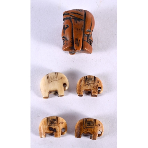 1046 - AN UNUSUAL ANTIQUE CARVED MEMENTO MORI NUT TOGGLE together with four carved bone tribal elephant tog... 