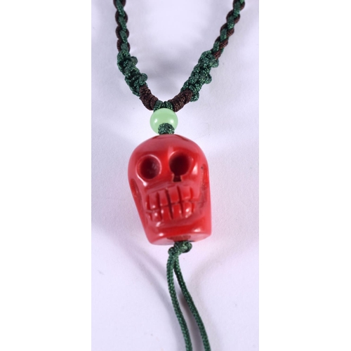 1103 - A CARVED CORAL SKULL PENDANT. 11 grams. 60 cm long.