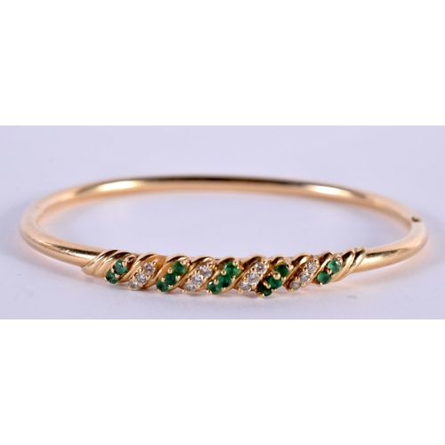 1150 - A 14CT GOLD BANGLE SET WITH EMERALDS AND DIAMONDS.  Stamped 14K, 5.8 cm x 5cm, weight 7.5g