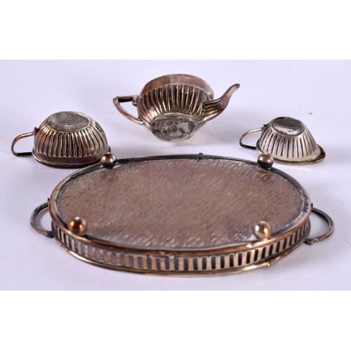 1242 - A SILVER MINIATURE TEA SET ON A TRAY.  Hallmarked Birmingham 1904, Tray 10.1cm x 5.8 cm x 1.5cm, tot... 