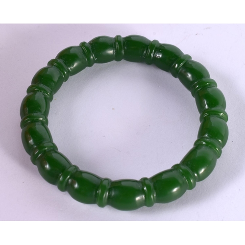 1300 - A RIBBED GREEN JADE BANGLE.  Internal 5.7cm, weight 43.7g