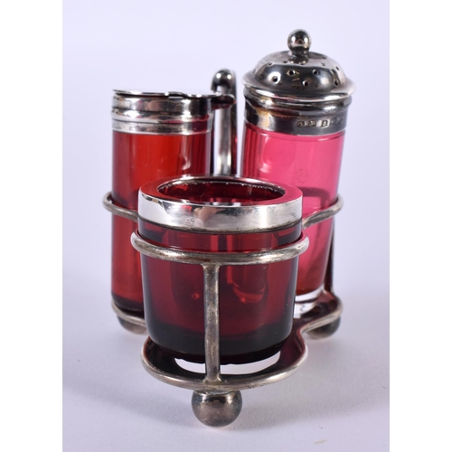 1377 - A SILVER AND CRANBERRY GLASS CRUET SET.  Hallmarked Birmingham 1902.  Overall 10cm x 7.5cm x 6 cm, t... 