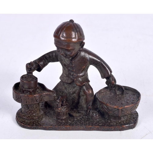 1437 - A BRONZE MODEL OF A BOY SEATED PREPARING FOOD .  7.5cm x 6 cm x 3.2 cm, weight 210g