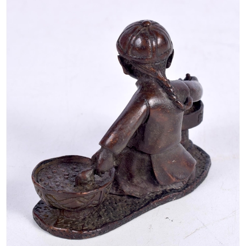 1437 - A BRONZE MODEL OF A BOY SEATED PREPARING FOOD .  7.5cm x 6 cm x 3.2 cm, weight 210g