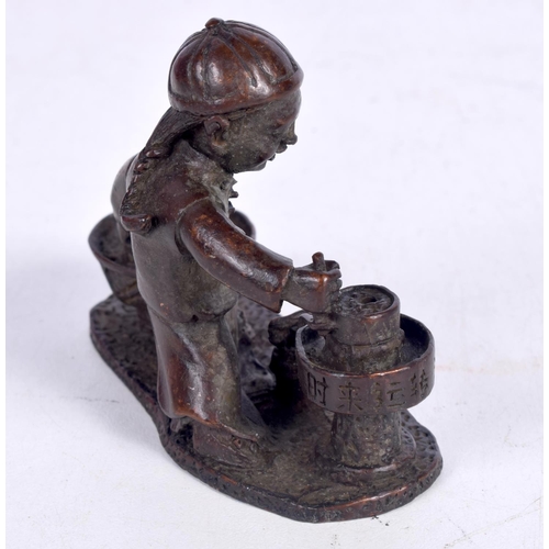 1437 - A BRONZE MODEL OF A BOY SEATED PREPARING FOOD .  7.5cm x 6 cm x 3.2 cm, weight 210g