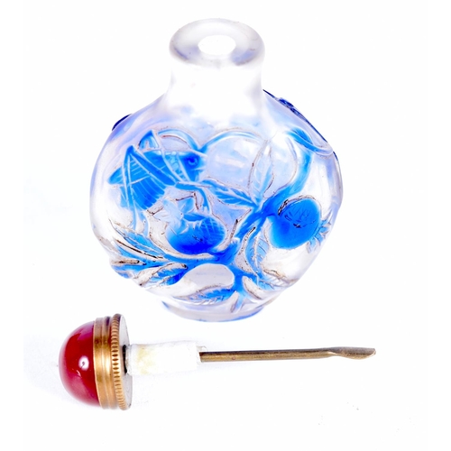 1442 - A PEKING GLASS SNUFF BOTTLE OVERLAID WITH BLUE GLASS FLOWERS.  7.5cm x 4.9cm x 2.7cm, weight 73g