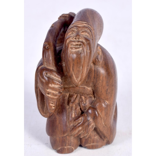 1447 - A JAPANESE CARVED HARDWOOD FIGURE OF AN OLD MAN STIRRING A COOKING POT.  5.4cm x 3.5cm x 3cm, weight... 