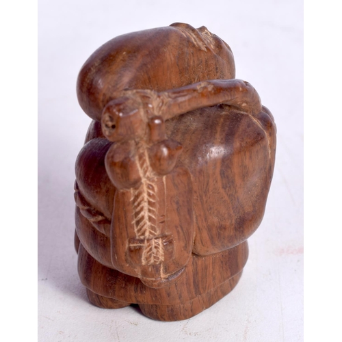 1447 - A JAPANESE CARVED HARDWOOD FIGURE OF AN OLD MAN STIRRING A COOKING POT.  5.4cm x 3.5cm x 3cm, weight... 