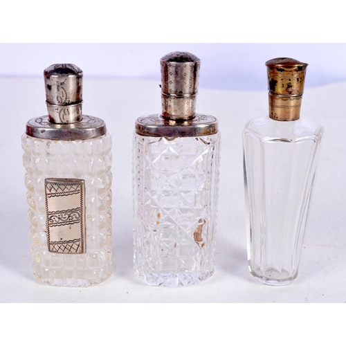 1465 - THREE SILVER MOUNTED SCENT BOTTLES.  Largest 8.8 cm x 3cm (3)