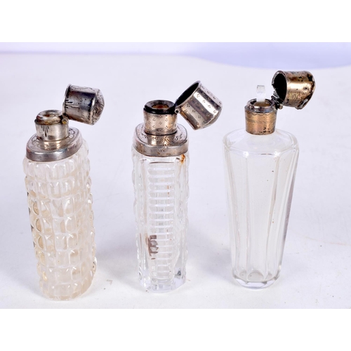 1465 - THREE SILVER MOUNTED SCENT BOTTLES.  Largest 8.8 cm x 3cm (3)