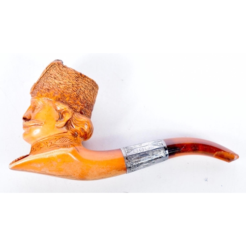 1475 - A MEERSCHAUM PIPE CARVED WITH THE HEAD OF A COSSACK WITH AN AMBER STEM WITH A CONTINENTAL SILVER COL... 