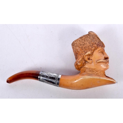 1475 - A MEERSCHAUM PIPE CARVED WITH THE HEAD OF A COSSACK WITH AN AMBER STEM WITH A CONTINENTAL SILVER COL... 