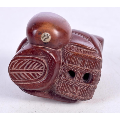 1516 - A JAPANESE CARVED WOOD NETSUKE OF DAIKOKU STANDING ON A RICE BALE.  5.2 cm x 4cm x 4.5cm, weight 54g