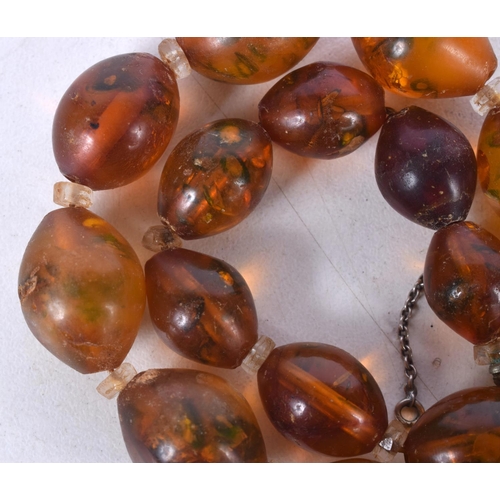 1624 - AN AMBER TYPE NECKLACE. 53 grams. 70 cm long, largest bead 2.25 cm x 2 cm.