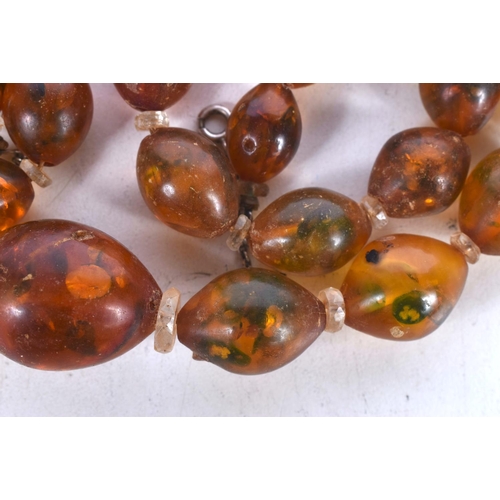 1624 - AN AMBER TYPE NECKLACE. 53 grams. 70 cm long, largest bead 2.25 cm x 2 cm.