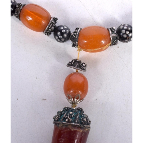 1645 - AN EASTERN AMBER NECKLACE. 74 grams. 42 cm long, largest bead 2.5 cm x 2 cm.