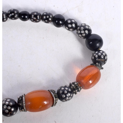 1645 - AN EASTERN AMBER NECKLACE. 74 grams. 42 cm long, largest bead 2.5 cm x 2 cm.