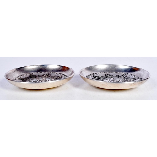 1648 - A PAIR OF CHINESE WHITE METAL COIN DISHES. 243 grams. 8.75 cm diameter.