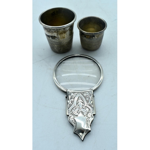 1764 - A SILVER MAGNIFYING MIRROR and a two white metal thimbles. 100 grams overall. Largest 11cm long. (3)