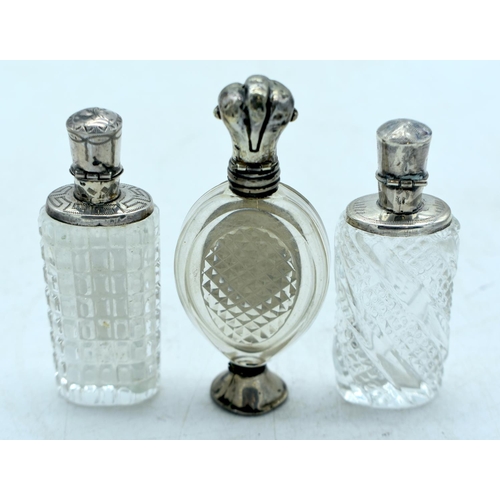 1821 - THREE CONTINENTAL SILVER TOPPED SCENT BOTTLES.  Largest 9.9cm x 4.3cm (3)