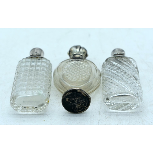 1821 - THREE CONTINENTAL SILVER TOPPED SCENT BOTTLES.  Largest 9.9cm x 4.3cm (3)