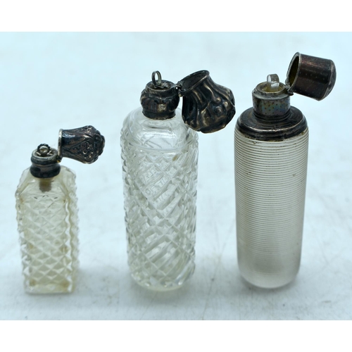 1824 - THREE CONTINENTAL SILVER TOPPED SCENT BOTTLES.  Largest 9.7cm x 3.4cm (3)