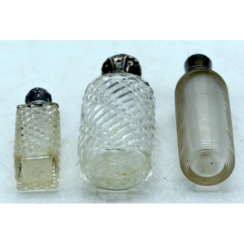 1824 - THREE CONTINENTAL SILVER TOPPED SCENT BOTTLES.  Largest 9.7cm x 3.4cm (3)