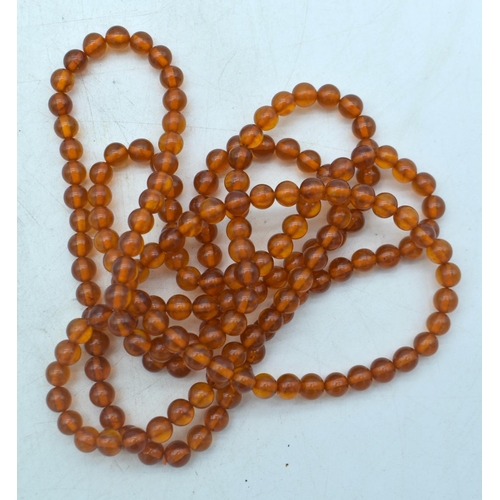 1848 - THREE AMBER COLOURED BEAD NECKLACES.  Longest 148cm (3)