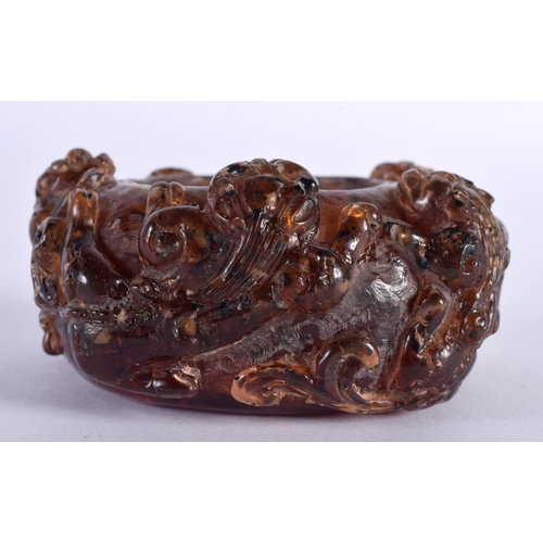 2005 - A CHINESE QING DYNASTY CARVED AMBER SCHOLARS BRUSH WASHER overlaid with clambering buddhistic lions.... 